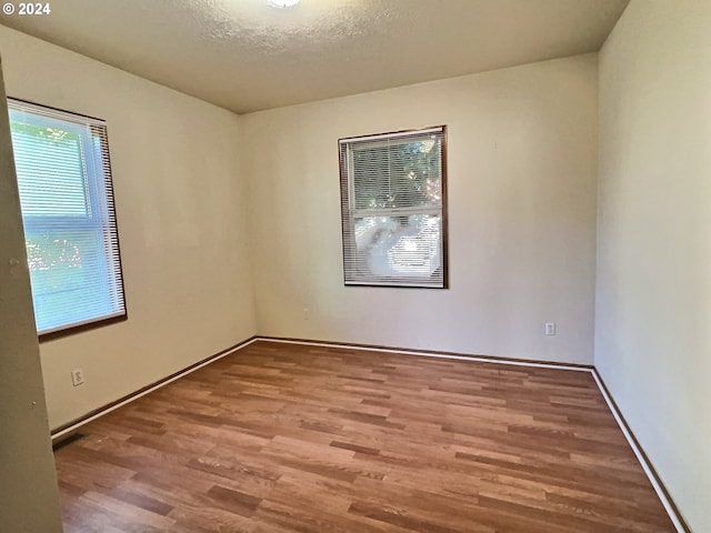 spare room featuring a textured ceiling and hardwood / wood-style floors