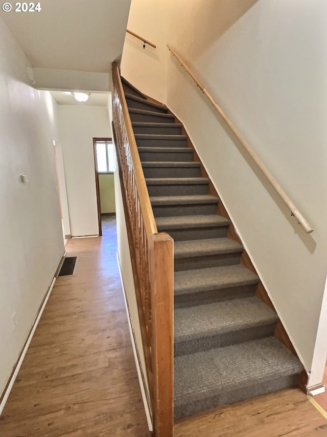 stairs featuring hardwood / wood-style flooring