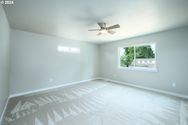 empty room with light carpet, a healthy amount of sunlight, and ceiling fan