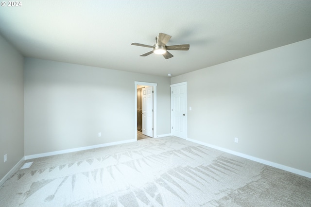 empty room featuring light colored carpet and ceiling fan