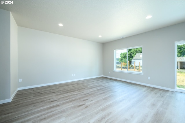 unfurnished room featuring a wealth of natural light, light wood finished floors, and recessed lighting