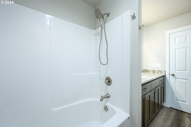 bathroom featuring hardwood / wood-style floors, vanity, and shower / bathing tub combination