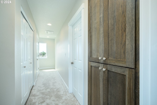 hall featuring light colored carpet