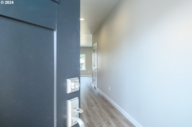 hallway featuring a textured ceiling and light hardwood / wood-style flooring