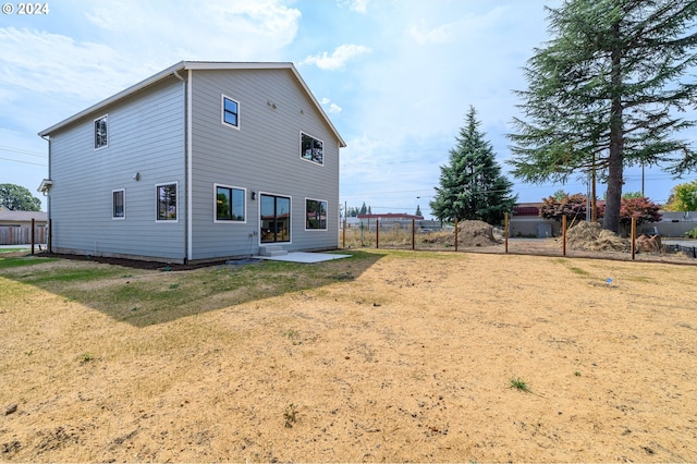 rear view of property featuring a patio area and a yard