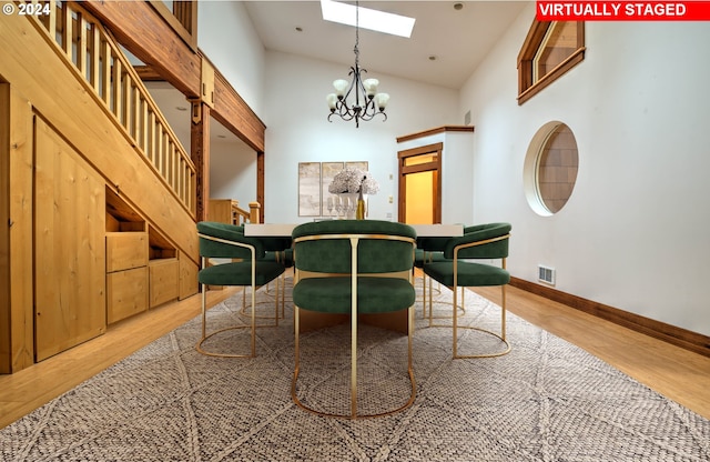 89464 Sunny Loop Ln, Bandon, OR 97411 - dining area with a skylight, light wood-type flooring, a chandelier, high vaulted ceiling, and stairs