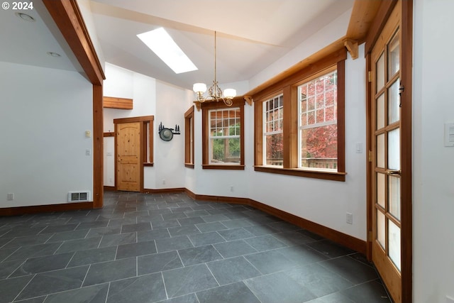 unfurnished dining area with a chandelier and a skylight