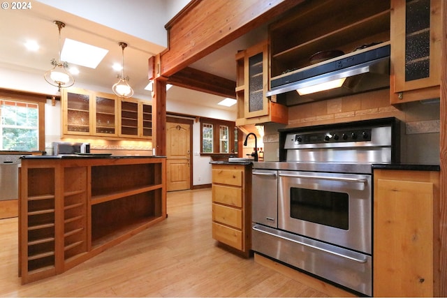 kitchen featuring ventilation hood, stainless steel electric stove, sink, decorative light fixtures, and light hardwood / wood-style flooring