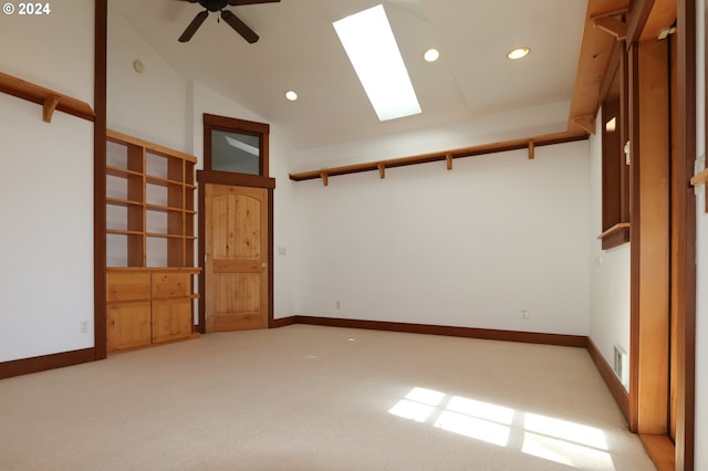 unfurnished bedroom with light carpet, a skylight, high vaulted ceiling, and ceiling fan