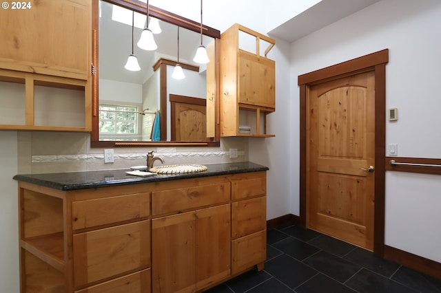 kitchen featuring dark tile patterned flooring, decorative backsplash, sink, and decorative light fixtures