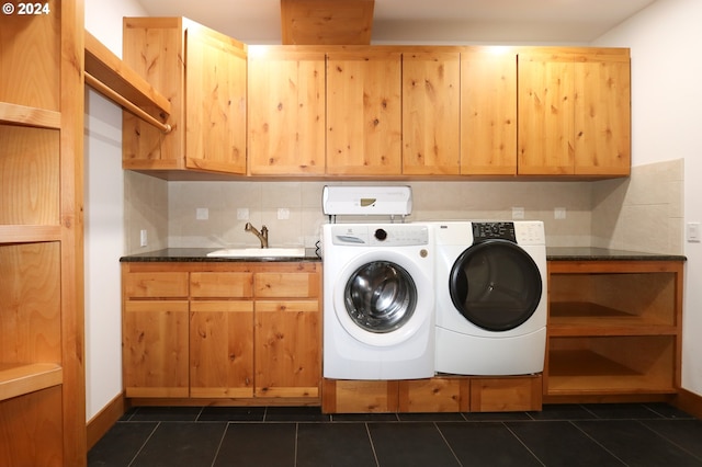 clothes washing area with cabinets, dark tile patterned flooring, washer and dryer, and sink