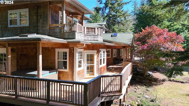 back of house with a balcony and a wooden deck