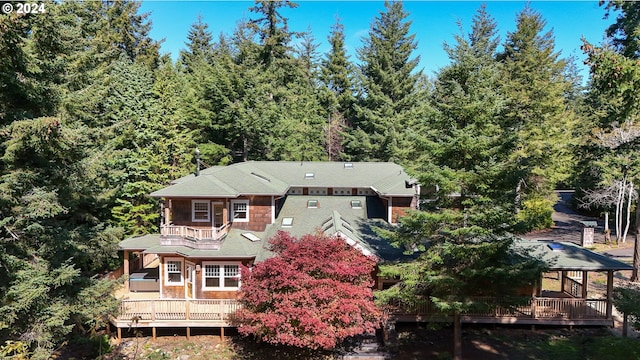 89464 Sunny Loop Ln, Bandon, OR 97411 - rear view of house featuring a balcony, a wooden deck, and a wooded view