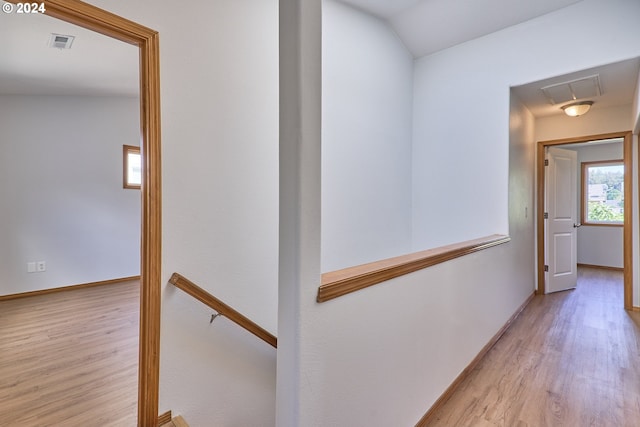 hallway featuring light wood-type flooring and lofted ceiling