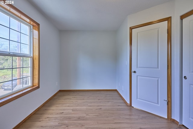 empty room with a textured ceiling and light wood-type flooring