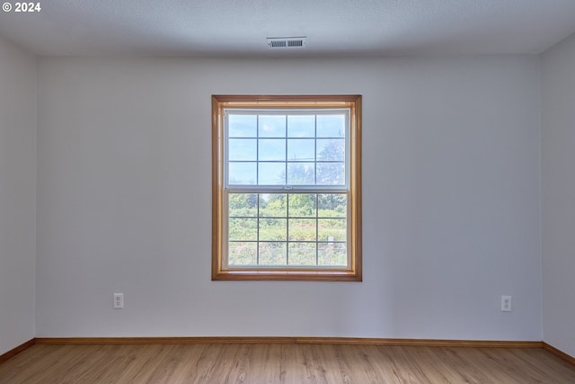 empty room featuring a textured ceiling and light wood-type flooring