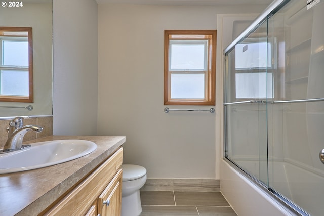 full bathroom with vanity, toilet, and combined bath / shower with glass door