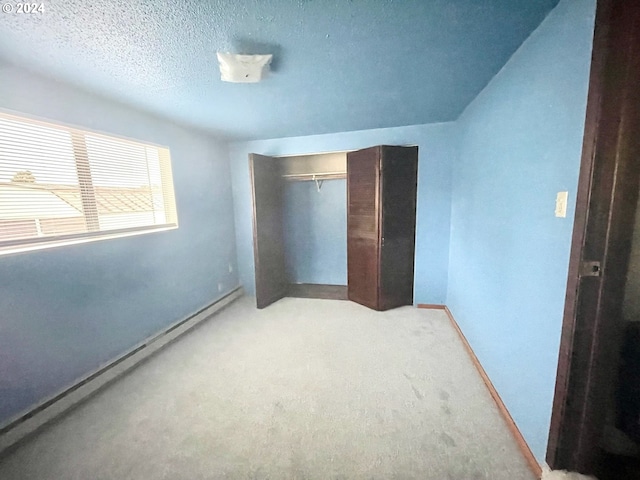 unfurnished bedroom with a closet, a textured ceiling, and light colored carpet