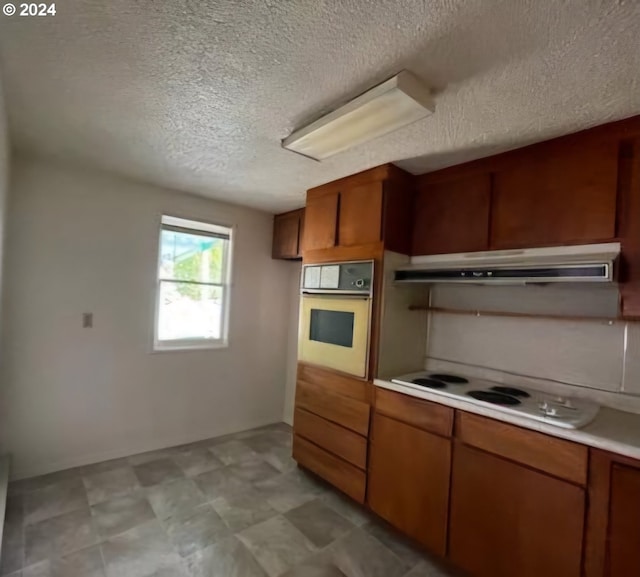 kitchen featuring white appliances and a textured ceiling