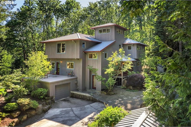 6733 NW Cornell Rd, Portland, OR 97229 - view of front of house with metal roof, driveway, a garage, and a deck