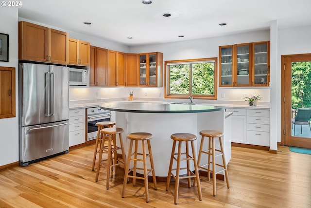 6733 NW Cornell Rd, Portland, OR 97229 - kitchen with appliances with stainless steel finishes, a kitchen island, healthy amount of natural light, light wood finished floors, and recessed lighting