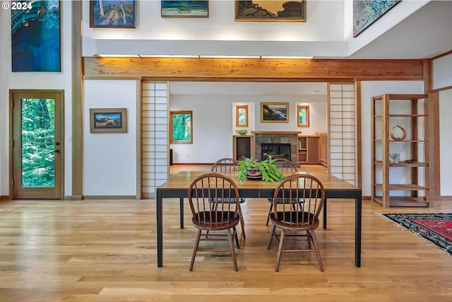 6733 NW Cornell Rd, Portland, OR 97229 - dining space featuring light wood-style flooring, a tiled fireplace, baseboards, and healthy amount of natural light