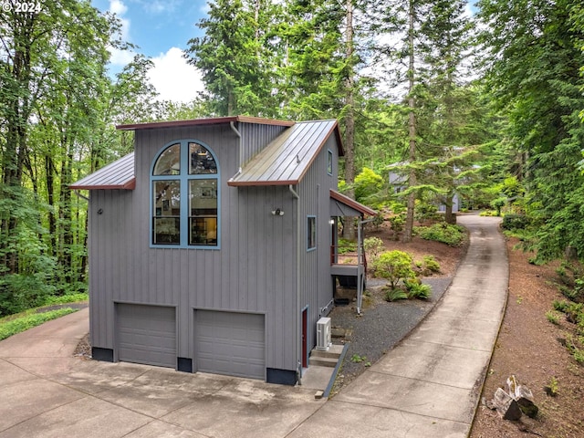 6733 NW Cornell Rd, Portland, OR 97229 - view of property exterior featuring a garage, metal roof, and concrete driveway