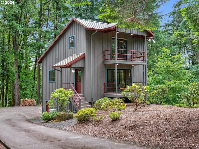 6733 NW Cornell Rd, Portland, OR 97229 - rustic home featuring a balcony, metal roof, a standing seam roof, and covered porch