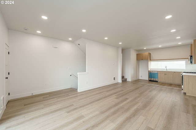 unfurnished living room with light hardwood / wood-style flooring, beverage cooler, and sink