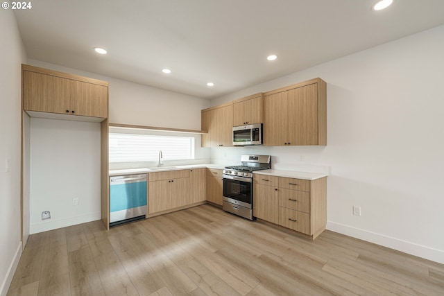 kitchen featuring sink, light brown cabinetry, stainless steel appliances, and light hardwood / wood-style floors