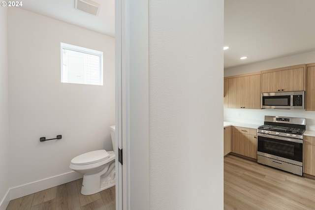 interior space with light brown cabinets, stainless steel appliances, and light wood-type flooring