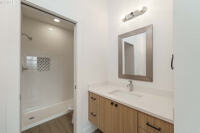 bathroom with hardwood / wood-style floors, vanity, and toilet