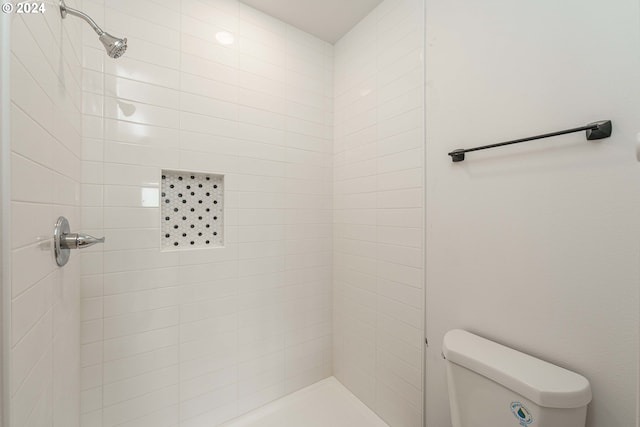 bathroom featuring toilet and tiled shower