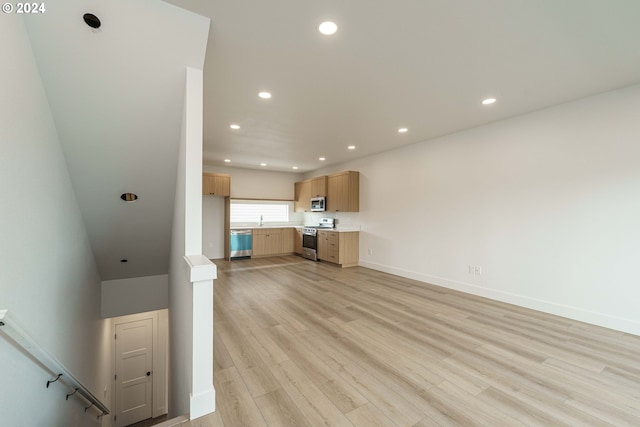 unfurnished living room featuring sink and light wood-type flooring