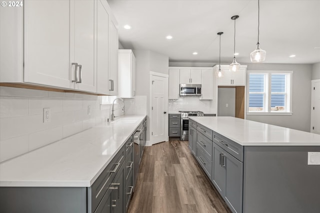 kitchen featuring gray cabinetry, a center island, sink, appliances with stainless steel finishes, and white cabinetry