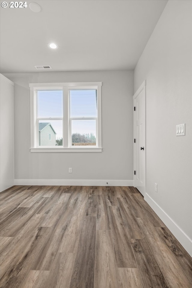 spare room featuring hardwood / wood-style floors and a healthy amount of sunlight