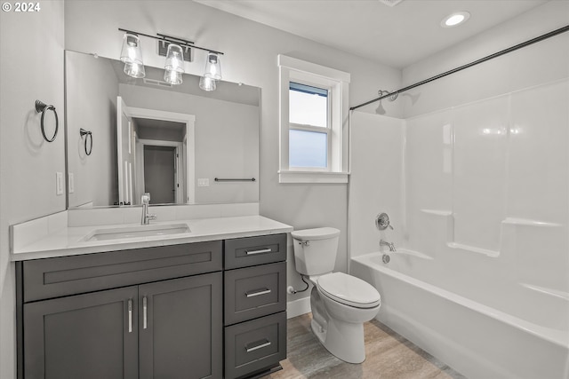 full bathroom featuring hardwood / wood-style flooring, vanity,  shower combination, and toilet