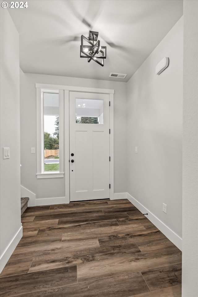 foyer entrance featuring dark hardwood / wood-style floors and a notable chandelier