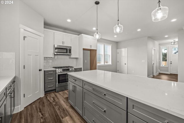 kitchen with gray cabinetry, backsplash, hanging light fixtures, appliances with stainless steel finishes, and white cabinetry