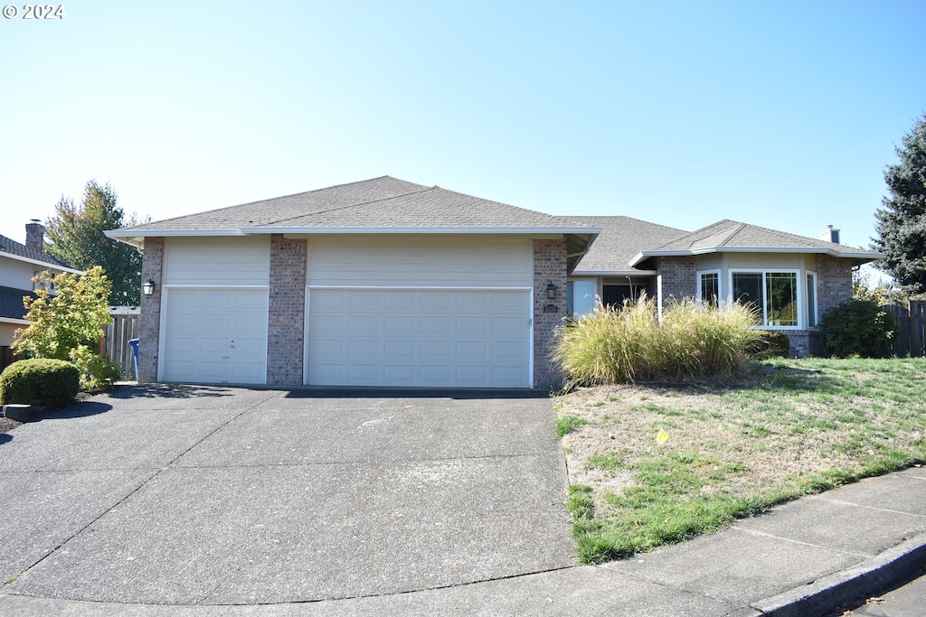 single story home with a front yard and a garage