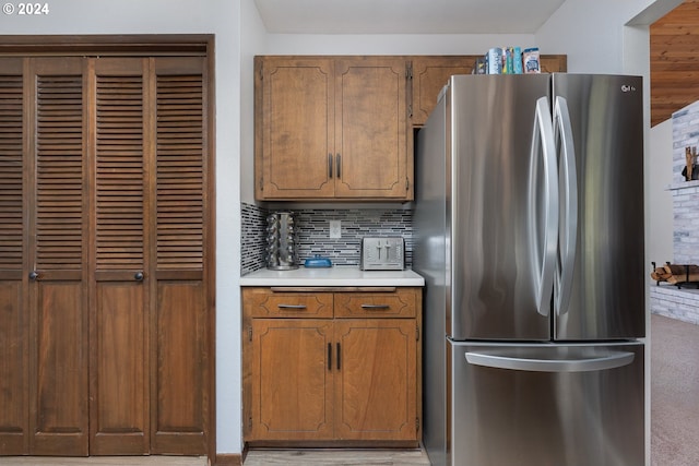 kitchen with stainless steel fridge and tasteful backsplash