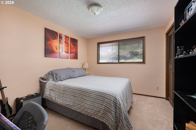 bedroom with a textured ceiling and light carpet