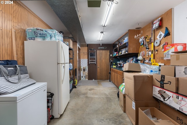 interior space with wooden walls and white fridge