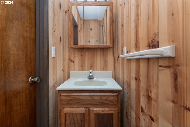 bathroom featuring wooden walls and vanity