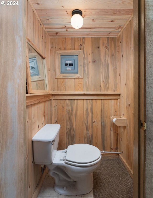 bathroom with wooden ceiling, wood walls, and toilet