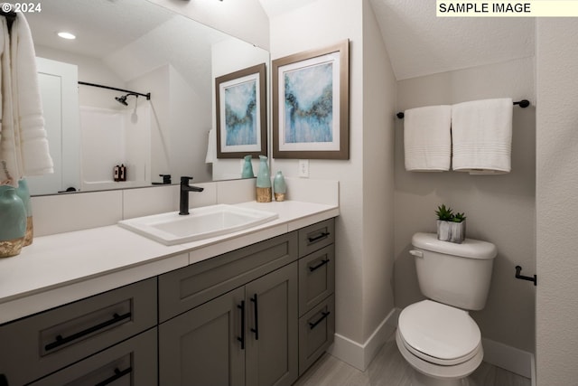 bathroom featuring walk in shower, a textured ceiling, vanity, toilet, and lofted ceiling