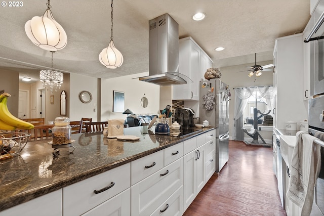 kitchen featuring dark hardwood / wood-style flooring, wall chimney exhaust hood, decorative light fixtures, white cabinets, and dark stone countertops