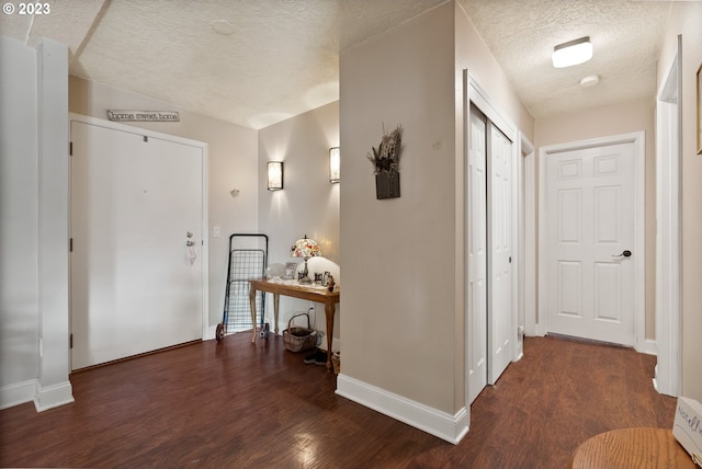 hall featuring a textured ceiling and dark hardwood / wood-style flooring