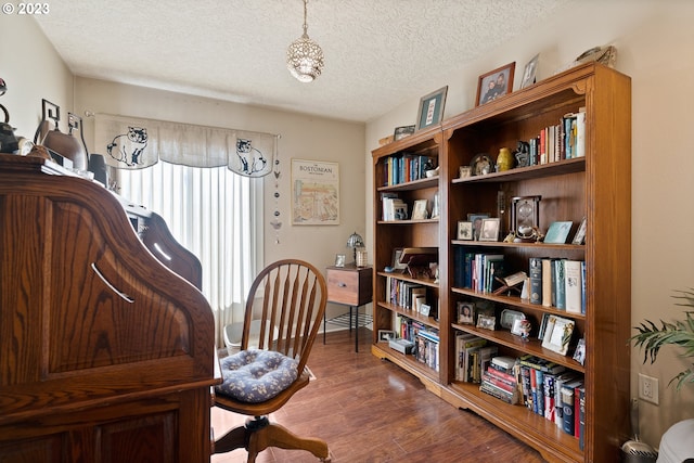 office with a textured ceiling and dark wood-type flooring