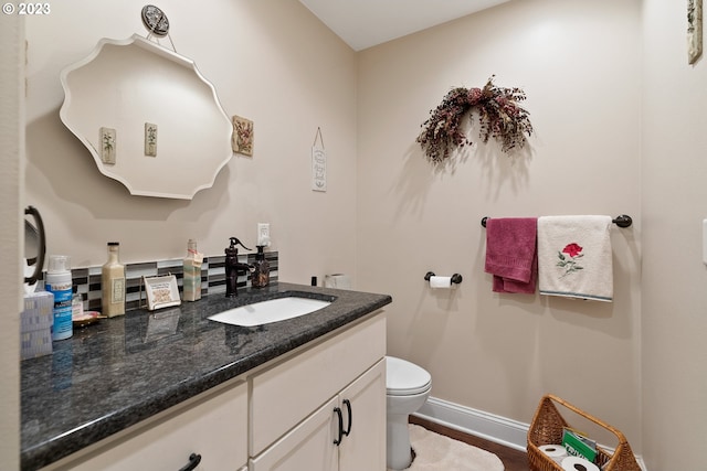 bathroom featuring vanity, wood-type flooring, and toilet